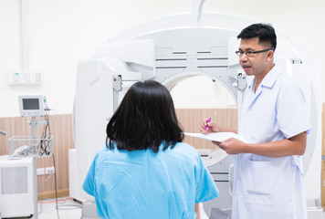 Asian radiologists explain treatment information to patients in x-ray room.CT (Computed tomography)...