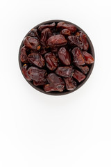 Dried dates in round bowl on white background, top view
