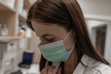 Closeup shot of tired pharmacist working during a coronavirus pandemic and wearing an anti-virus mask. Pharmacist looking for a medicines.
