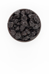 Dried plumps in round bowl on white background, top view