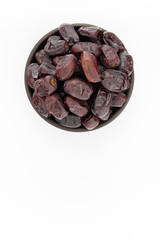 Dried dates in round bowl on white background, top view