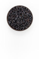 Fototapeta na wymiar Black raisins in round bowl on white background, top view