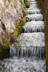 caída de agua por escaleras proveniente de la fuente de los 100 caños de Villanueva del Trabuco en Andalucía, España