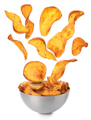 Sweet potato chips falling into bowl on white background