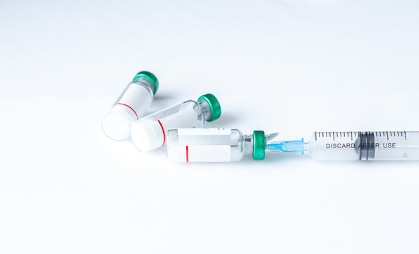 Syringe with a vaccine Coronavirus, COVID-19, nCoV 2019 and flu vaccine on white background. Medicine infectious concept. Measles vaccine. Laboratory test. Population vaccination . New medicine 