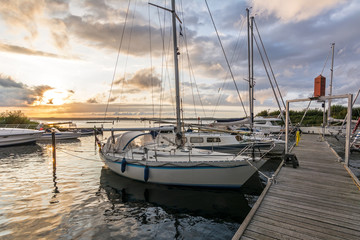 Fototapeta na wymiar Sailing boats in a marina during a beautiful colourful sunset at the Baltic Sea