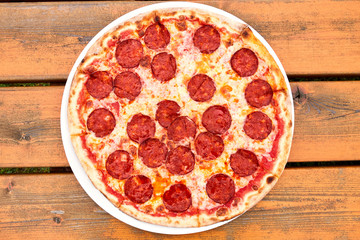 A pepperoni pizza sitting on top of a wooden table