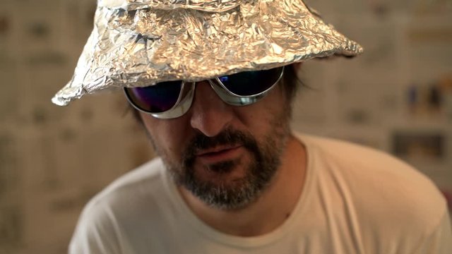 Delusional paranoid man with tin foil hat talking