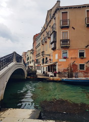 The bridge over venetian canal after the rain, ancient architecture of Italy