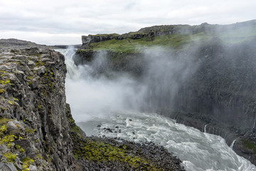 Northern europe most powerful waterfall, the dettifoss in Iceland during early morning hours. Soft light and cloudy sky with big mist swirls. Travelling, holiday and icelandic concept.