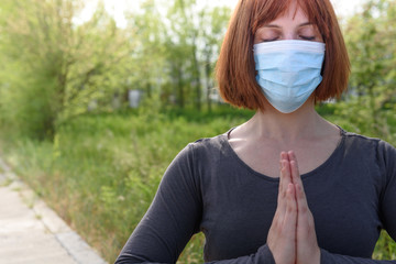 Girl in lotus position with sirurgical mask in nature background.