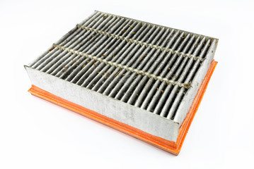 Worn and dirty rectangular car air filter, visible leaves and dirt, isolated on white background with a clipping path, bottom filter side visible