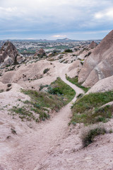 A path among the pink cliffs of Cappadocia. Tourism and travel. Beautiful landscape. Vertical.