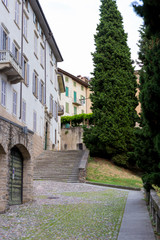 Fototapeta na wymiar Traditional narrow Italian street with staircase and no people in Bergamo historical center, Italy. Medieval buildings. There's no one on the street.