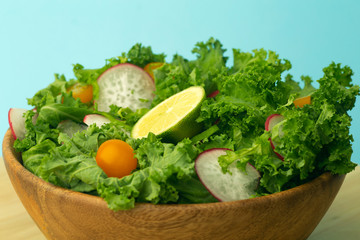 Fresh green salad in a wooden bowl. Healthy, diet, vitamins, vegetarian,  proper food and lifestyle concept.