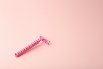 Female shaving razor on a pink background. Skin care, cosmetics, and female beauty concept.