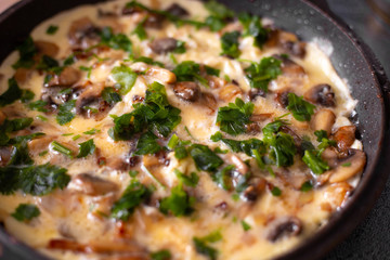authentic omelet with vegetables and mushrooms champignons in a pan, delicious nutritious breakfast,