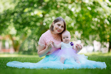 Portrait of a young mother and little daughter in a Park on a warm summer day.