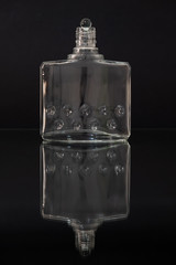 Bottle of aftershave has on the side a graphic representing water bubbles, on top of the neck of the bottle there is a glass marble, inside the bottle are visible water vapours.