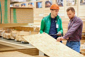 handsome man consults with warehouse worker in uniform, which size of wooden board will be suitable