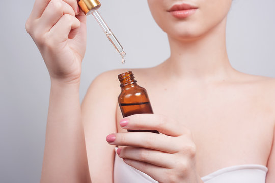 Massage therapist pouring essential oil onto hand in spa salon woman hand hold a spuit, dropping pipet, medicine pipette. Girl hand