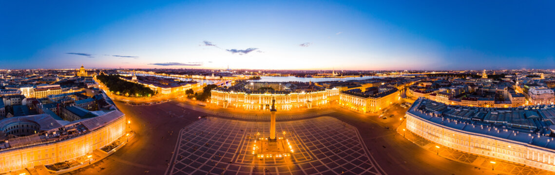 Aerial front view at the Winter Palace building in white nights, exterior Palace Square and Aleksandr Column at summer. Top view from drone. Saint-Petersburg, Russia