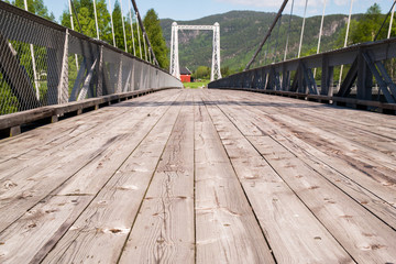 A long old Gulsvik Bro bridge made of wooden planks. The Norwegian mountains.