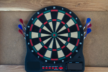electronic dartboard on wooden background