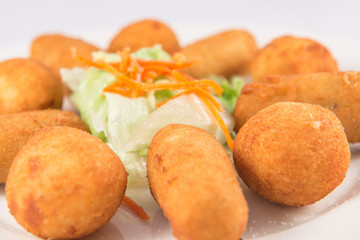Plate of mixed ham and cod croquettes with lettuce.