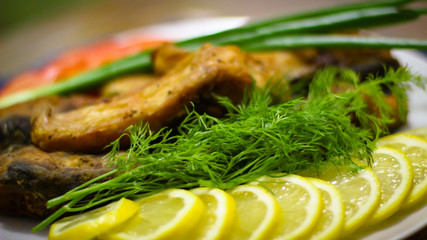 A Few Slices Of Fried Fish And Sliced Lemon Slits On A White Plate. Around The Decor Of The Sea Themes.