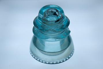 Antique glass insulator from a telephone line isolated on a white background