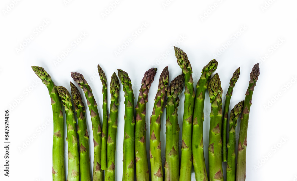 Wall mural bunch of fresh raw asparagus on white background, vegetarian concept. green grass sparrowgrass stick