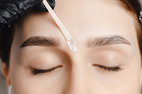 Master wax depilation of eyebrow hair in women, brow correction