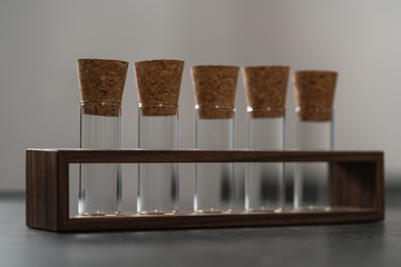 empty walnut holder with glass tubes for spices on concrete surface