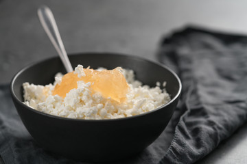 Cottage cheese with orange jam in white bowl on concrete background