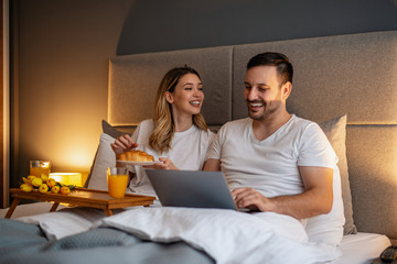 Portrait of happy couple in bedroom
