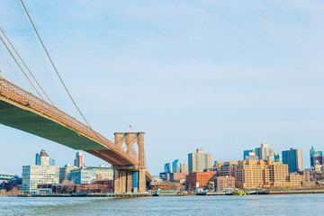 Brooklyn Bridge over river viewed from New York City.
