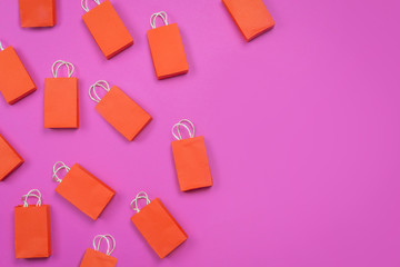 many red shopping bags on pink background. copy space. concept of shopping
