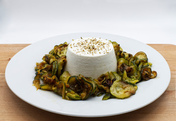 Cottage cheese with zucchini and oregano on wooden table