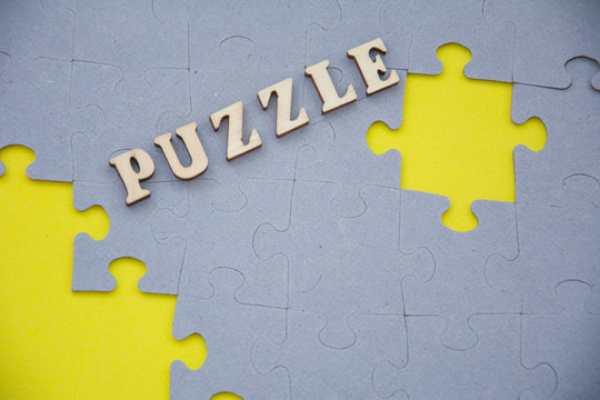 Missing jigsaw puzzle piece on yellow background. Label PUZZLE on top. Home Board game concept. - Powered by Adobe