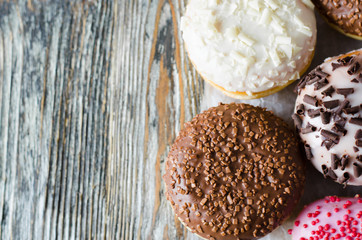 Traditional donut day. Assorted donuts with chocolate glazed on wooden background.