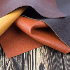 Natural leather textures samples on dark wooden background