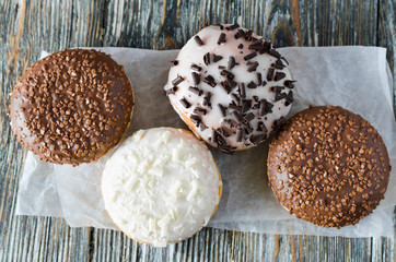 Traditional donut day. Assorted donuts with chocolate glazed on wooden background.