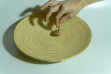 A Spinning Wooden Top on Wooden Round Plate