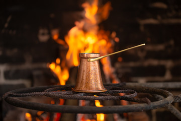 Brewing coffee in a Turk on an open fire .