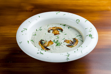 Cream soup of mushrooms on white plate