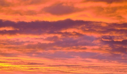 Fototapeta premium Wieczorne niebo w gęstych chmurach jasnopomarańczowego koloru