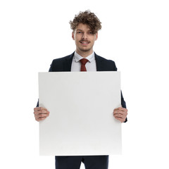 Positive businessman holding billboard and smiling