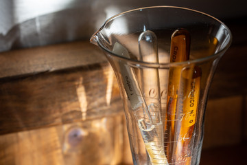 Glass ampoules containing silk sutures from the 1950s in a graduated cup. It is a way of containing...