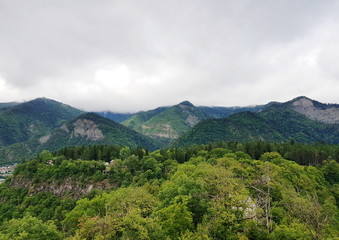 Fototapeta na wymiar Mountains covered with dense forests under a cloudy sky in Borjomi, Georgia